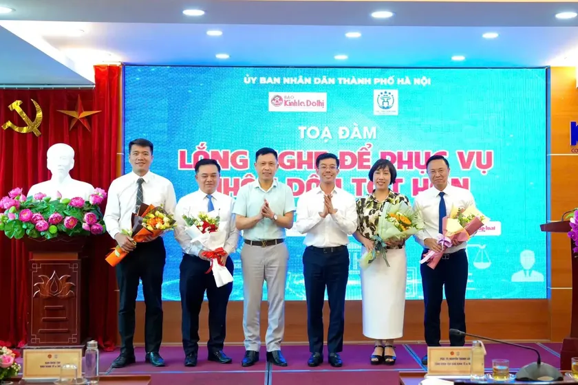 anh-3-2073-2237 PGS.TS Nguyễn Thành Lợi - Tổng Biên tập Báo Kinh tế & Đô thị và ông Cù Ngọc Trang, Giám đốc Trung tâm Phục vụ hành chính công TP Hà Nội tặng hoa các diễn giả tham gia tọa đàm. (Ảnh: KT&ĐT)